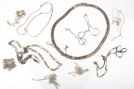 A collection of silver and white metal necklaces.