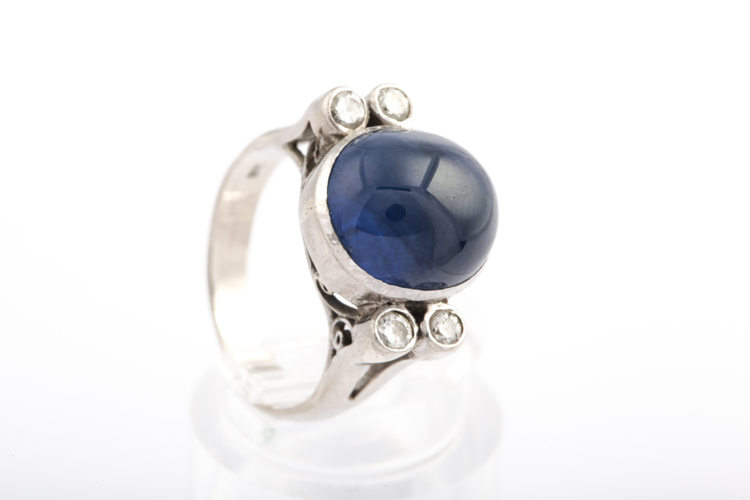 A mid-20th century cabochon sapphire and diamond dress ring.