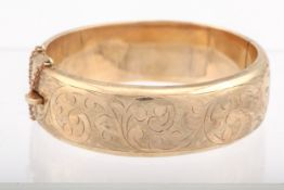 A vintage 9ct gold part foliate engraved hollow half-hoop hinged bangle.