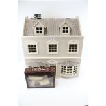 A contemporary made dolls house. In the form of a town house with bay windows and two floors.