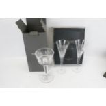 A Waterford Crystal boxed candlestick centre piece and a pair of boxed flutes