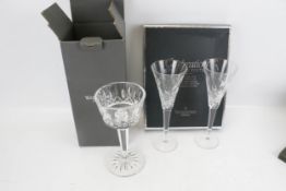 A Waterford Crystal boxed candlestick centre piece and a pair of boxed flutes
