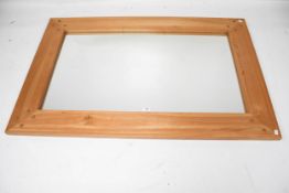 A contemporary wooden framed wall mirror.