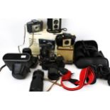 A collection of assorted vintage cameras and binoculars.