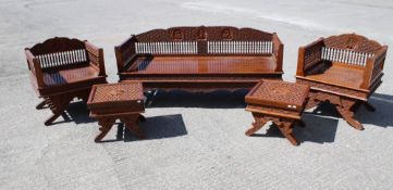 A heavy carved wooden three piece suite.