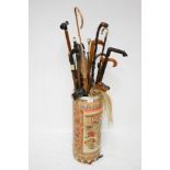 An oriental stick stand and a collection of walking sticks.