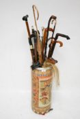 An oriental stick stand and a collection of walking sticks.