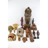 A collection of wooden carvings. Including tribal figures, a laughing buddha, masks, etc.