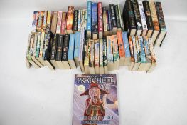 A large collection of Terry Pratchett books. Including 'The Wee Free Men', 'Jingo', etc.
