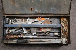 A vintage cast metal toolbox containing assorted tools.