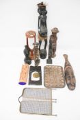 A collection of carved wooden items. Including African figures, masks, a wooden stand, etc.