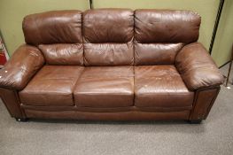 A contemporary brown leather three seater sofa.