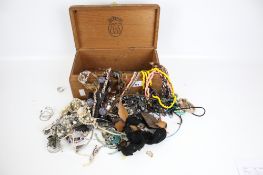 A collection of assorted costume jewellery in a wooden box. Including mostly necklaces, etc.