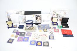 An assortment of collectable coins, first day covers and banknotes.