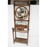 An Edwardian dark oak hallstand. With leaded glass panel and circular mirror, label 'J.