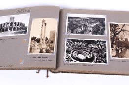 A vintage photograph album containing postcards and photographs.