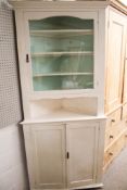 A vintage white painted corner display cupboard.