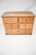 A vintage pine chest of drawers. Two short over two short and one long. On bun feet.