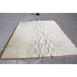 A cream carpet with acanthus leaf boarder.