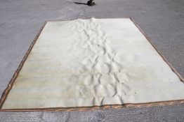 A cream carpet with acanthus leaf boarder.
