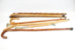 A collection of seven assorted walking sticks. Including a brass eagle head handle, etc.