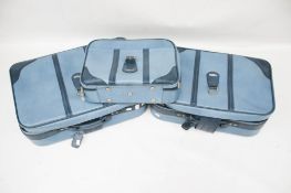 Three Antler blue leatherette suitcases.