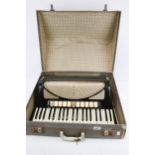 A vintage Hohner Verdi V piano accordion in case.