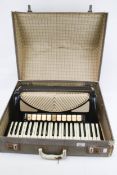 A vintage Hohner Verdi V piano accordion in case.