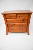 A contemporary chest of stained pine drawers.