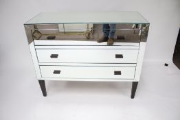 A contemporary mirrored chest of drawers.