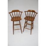 A pair of stained pine bar stools.