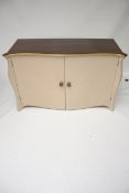 A contemporary serpentine commode style two door sideboard cabinet.