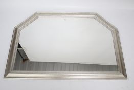 A wall mirror with a silver frame.