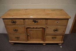 A large Victorian pine sideboard with drawers and central small cupboard.