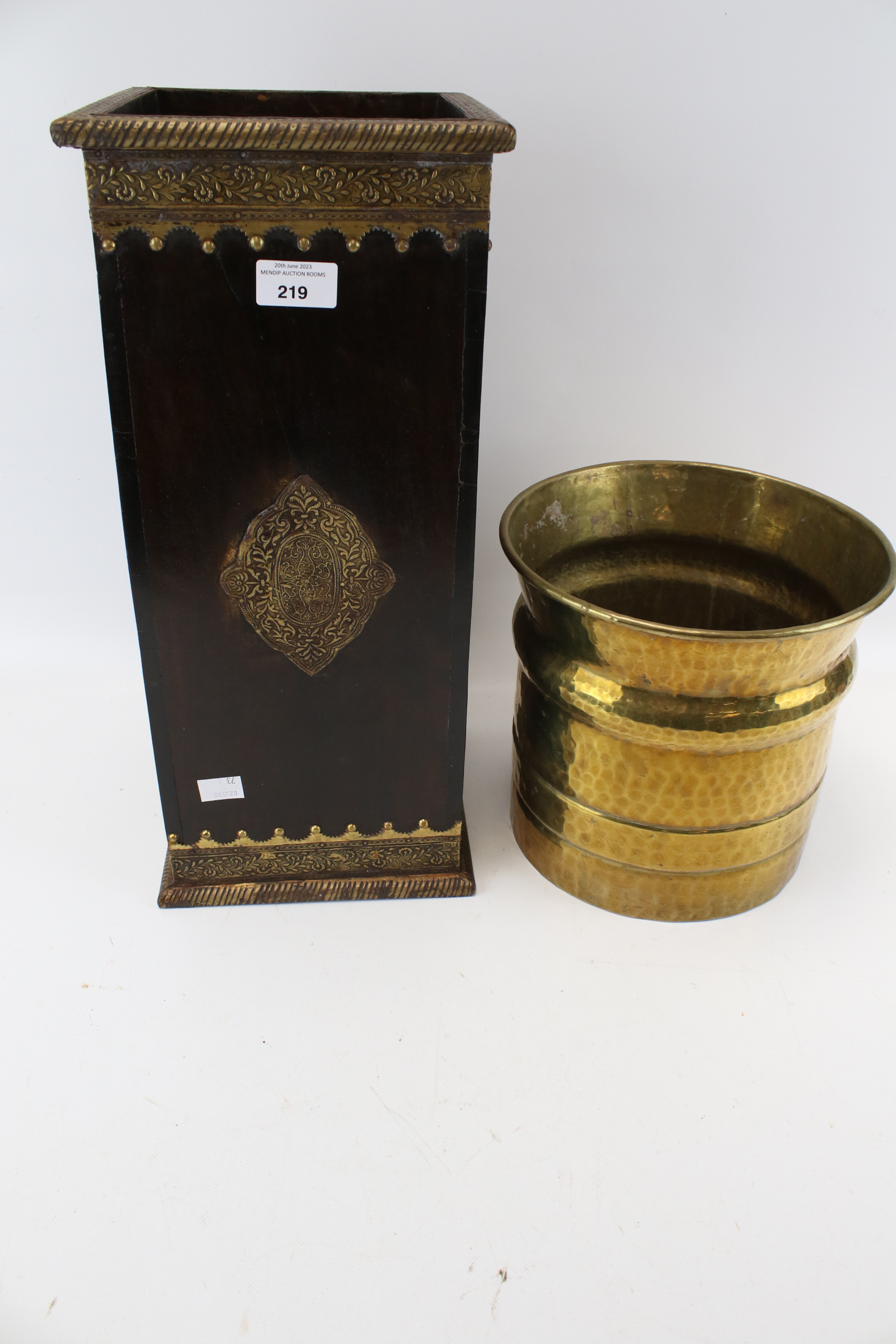 A square metal bound umbrella stand and a brass plant pot.