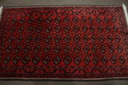 A Persian style red wool rug.