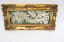 A contemporary resin cherub wall plaque in a gilt wood frame.
