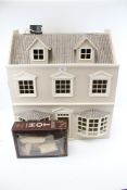 A contemporary dolls house. In the form of a town house with bay windows and two floors.