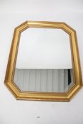 A bevel edge octagonal wall mirror in a gilt frame.