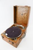 A vintage oak cased portable wind-up gramophone.