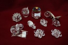 An assortment of Swarovski and cut glass and ceramic paperweights.
