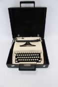 A cream 1970s portable Remington Ten Forty mechanical typewriter.