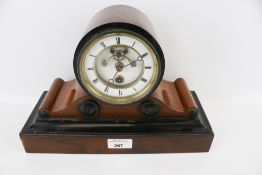 An early 20th century ebonised and mahogany mantel clock.