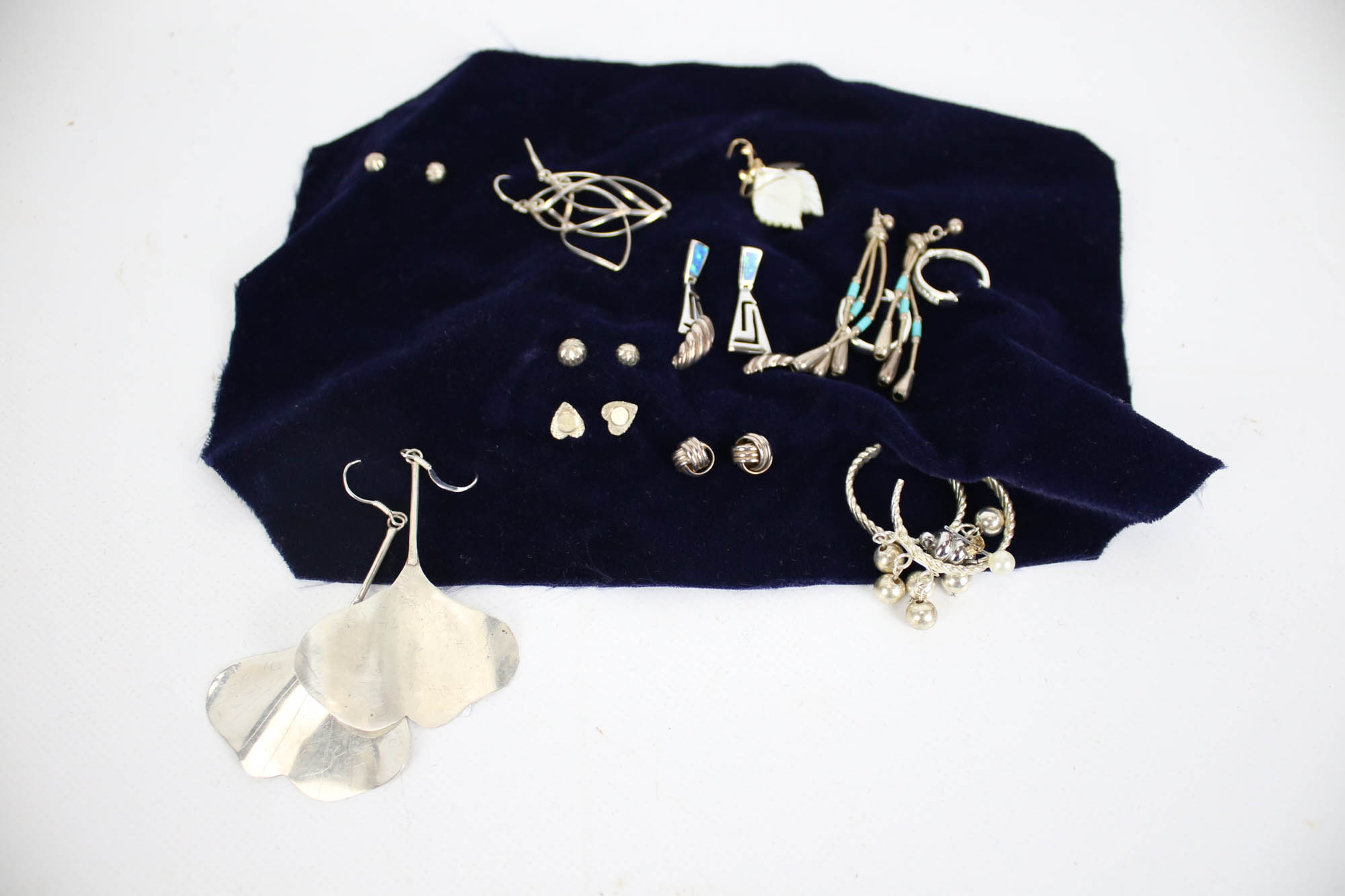 Twelve pairs of silver earrings in various designs