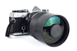 An Olympus OM-1 35mm SLR camera. With a 500mm Makinon mirror lens.