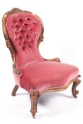 A Victorian walnut button back upholstered serpentine fronted chair with light red velvet covering.