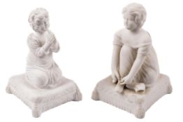 Two Victorian Parianware figures of Victorian children kneeling on cushions.