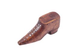 A 19th century snuff box. In the form of a walnut shoe with steel pique like decoration, 10 cm long.
