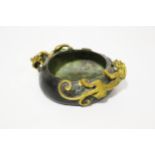 A Chinese Qing Dynasty patinated bronze censer with gilt rain dragons to edge.