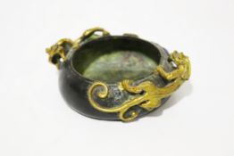 A Chinese Qing Dynasty patinated bronze censer with gilt rain dragons to edge.